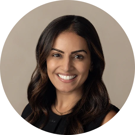 Female clinician smiling in a circular professional headshot with a neutral beige background